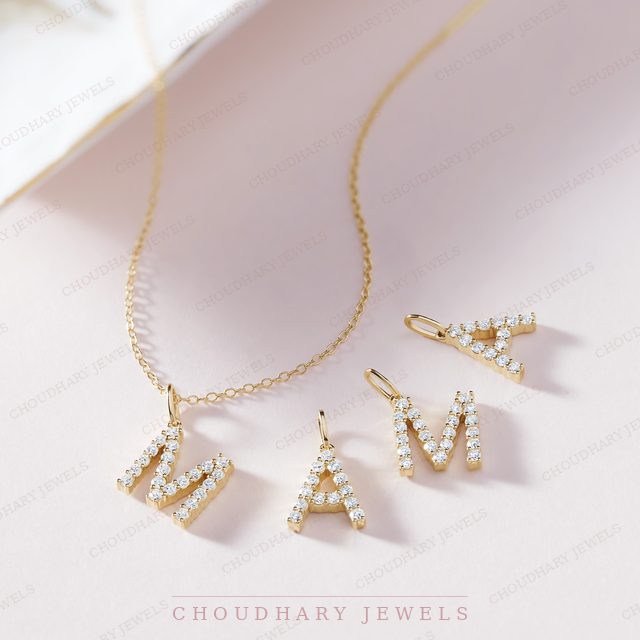 A yellow gold necklace with diamond-set initial letters spelling MAMA, two letters on the chain and two beside it.