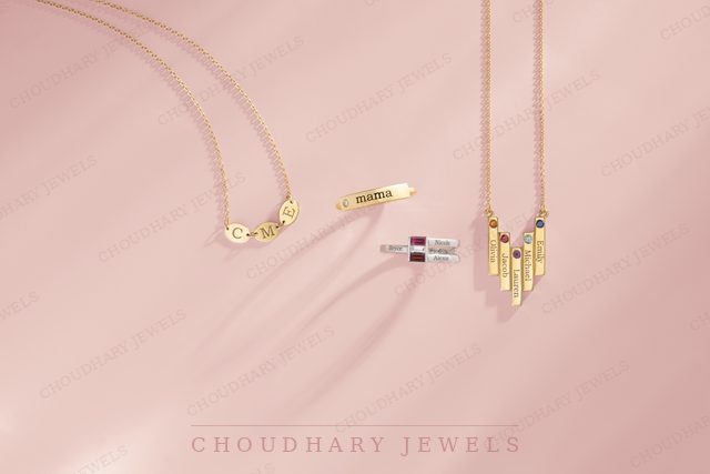 Yellow gold necklaces and a ring with small colored gemstones, including a pendant with vertical bars, on a pink background.