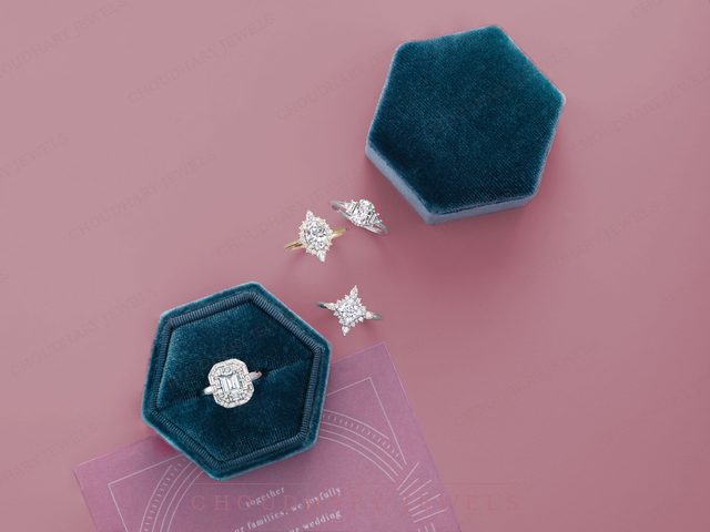 A white gold cushion halo engagement ring in a teal velvet hexagon box, with three star- and kite-shaped diamond rings on a pink background.